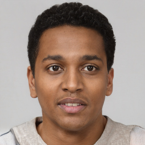 Joyful black young-adult male with short  black hair and brown eyes