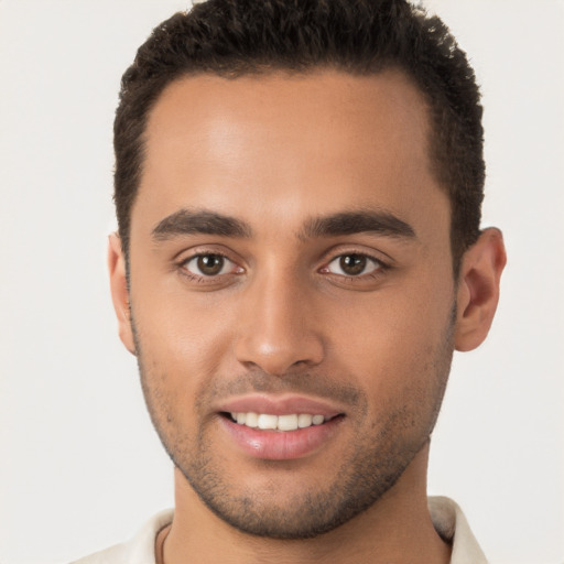 Joyful latino young-adult male with short  brown hair and brown eyes