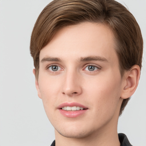 Joyful white young-adult male with short  brown hair and grey eyes