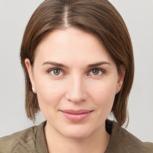 Joyful white young-adult female with medium  brown hair and grey eyes