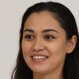 Joyful latino young-adult female with long  brown hair and brown eyes