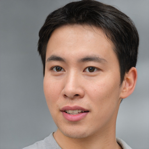 Joyful asian young-adult male with short  brown hair and brown eyes