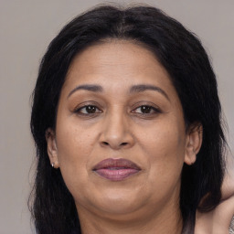 Joyful latino adult female with medium  brown hair and brown eyes