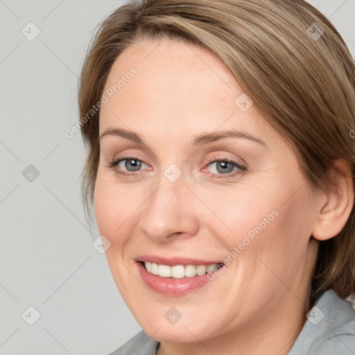 Joyful white adult female with medium  brown hair and blue eyes