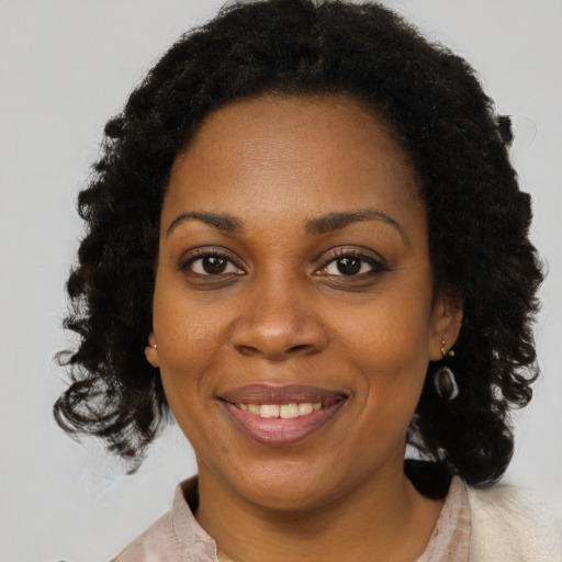 Joyful black adult female with medium  brown hair and brown eyes