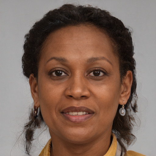 Joyful black adult female with medium  brown hair and brown eyes