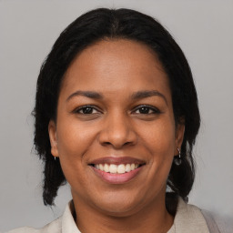 Joyful black adult female with medium  brown hair and brown eyes