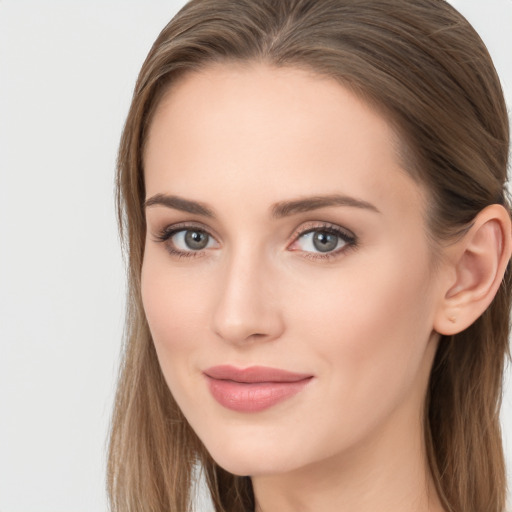 Joyful white young-adult female with long  brown hair and blue eyes