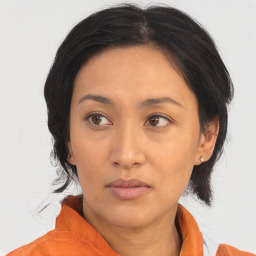 Neutral asian adult female with medium  brown hair and brown eyes