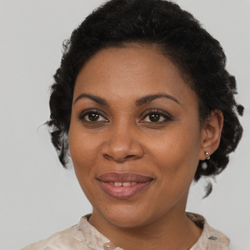 Joyful black adult female with short  brown hair and brown eyes