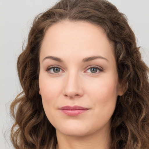 Joyful white young-adult female with long  brown hair and green eyes