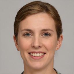 Joyful white young-adult female with medium  brown hair and blue eyes