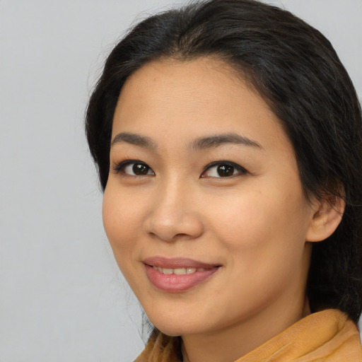 Joyful asian young-adult female with long  brown hair and brown eyes