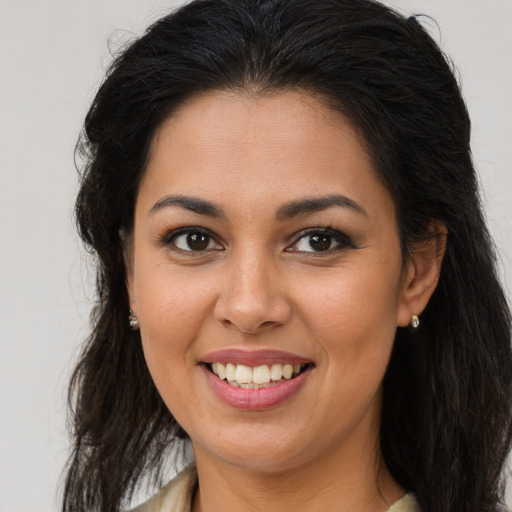 Joyful latino young-adult female with long  brown hair and brown eyes