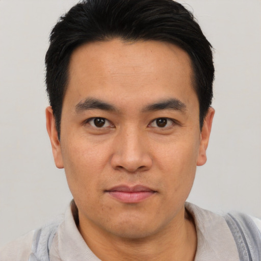 Joyful asian young-adult male with short  black hair and brown eyes