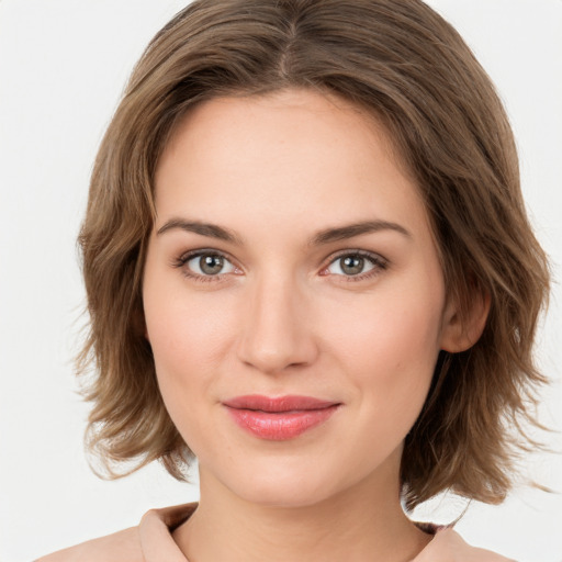 Joyful white young-adult female with medium  brown hair and green eyes