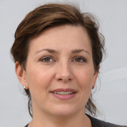 Joyful white adult female with medium  brown hair and grey eyes