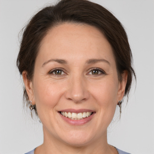 Joyful white adult female with medium  brown hair and brown eyes