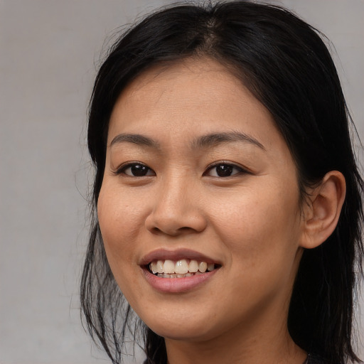 Joyful asian young-adult female with long  black hair and brown eyes