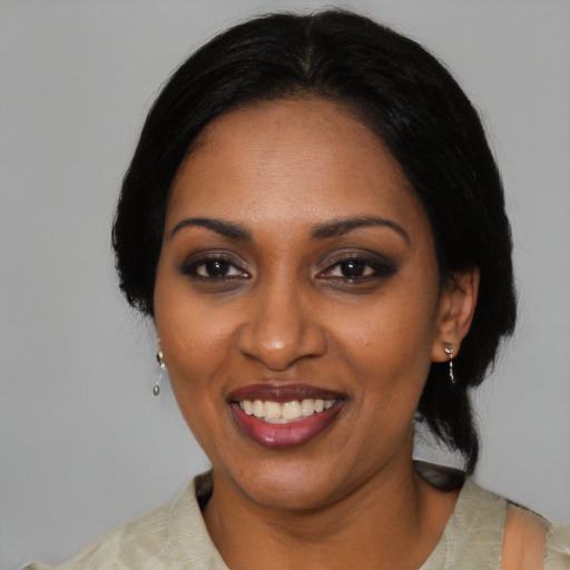 Joyful black adult female with medium  black hair and brown eyes