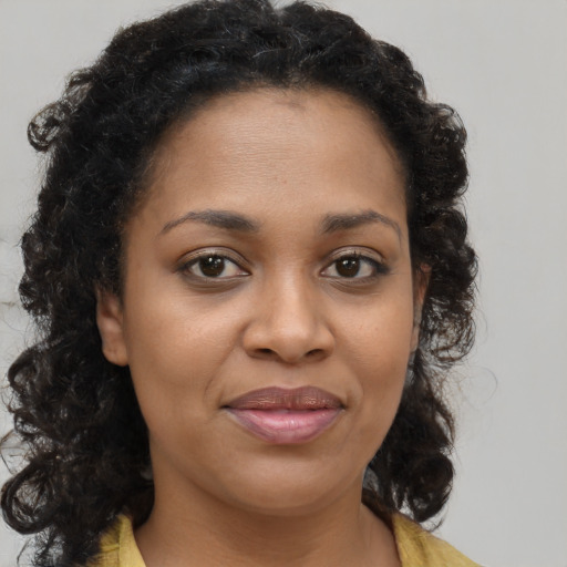 Joyful black young-adult female with medium  brown hair and brown eyes