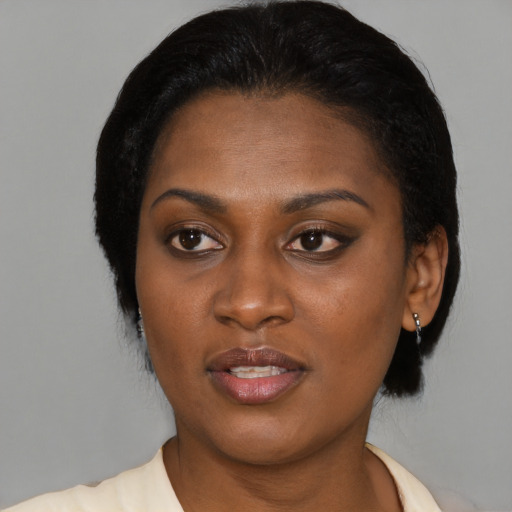 Joyful black young-adult female with short  black hair and brown eyes