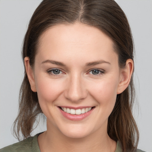 Joyful white young-adult female with medium  brown hair and grey eyes