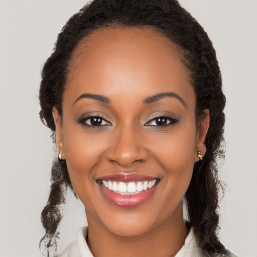 Joyful black young-adult female with long  brown hair and brown eyes