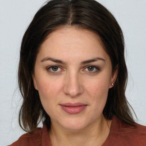 Joyful white young-adult female with medium  brown hair and green eyes