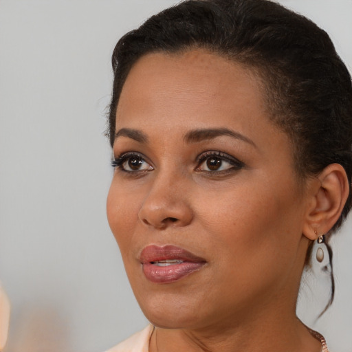 Joyful black young-adult female with medium  brown hair and brown eyes