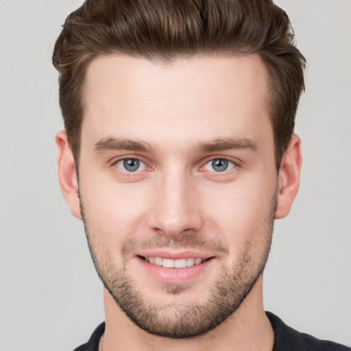 Joyful white young-adult male with short  brown hair and grey eyes