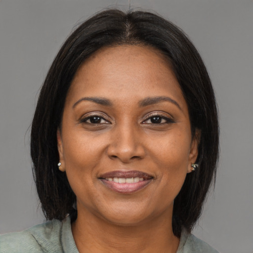 Joyful black adult female with medium  brown hair and brown eyes