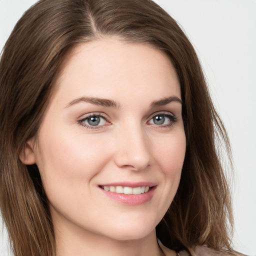 Joyful white young-adult female with long  brown hair and grey eyes