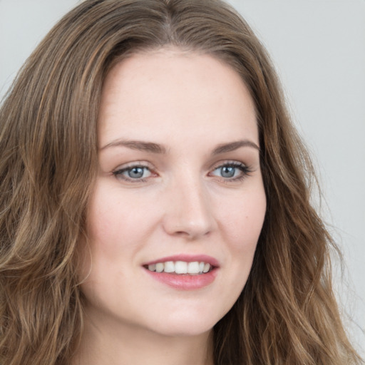 Joyful white young-adult female with long  brown hair and blue eyes