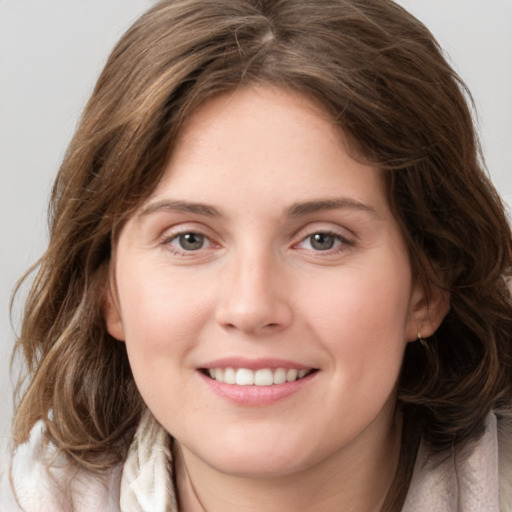 Joyful white young-adult female with medium  brown hair and grey eyes