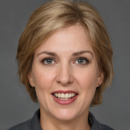 Joyful white adult female with medium  brown hair and grey eyes