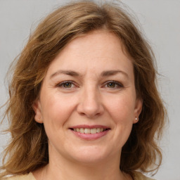 Joyful white adult female with medium  brown hair and grey eyes