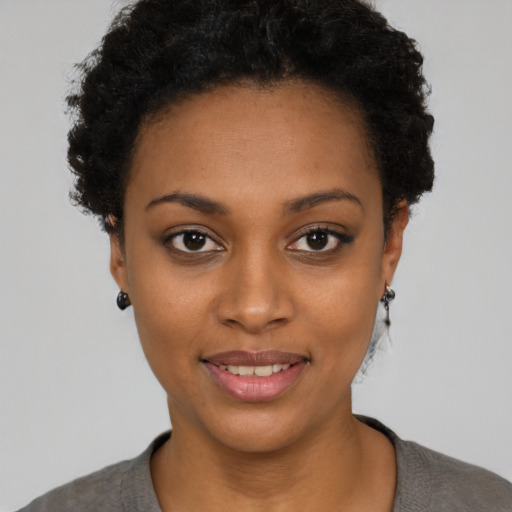 Joyful black young-adult female with short  black hair and brown eyes