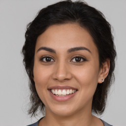 Joyful latino young-adult female with medium  brown hair and brown eyes