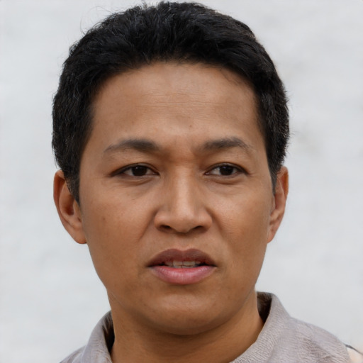Joyful latino adult male with short  black hair and brown eyes