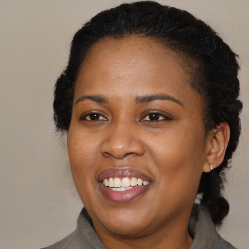 Joyful black adult female with medium  black hair and brown eyes