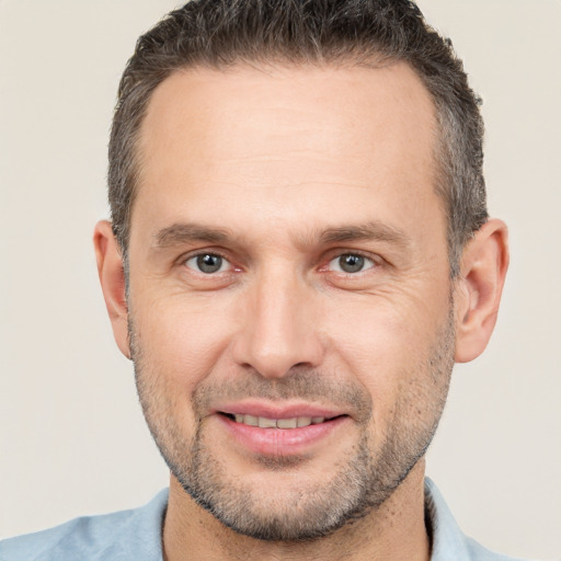 Joyful white adult male with short  brown hair and brown eyes