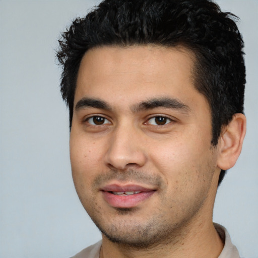 Joyful latino young-adult male with short  black hair and brown eyes