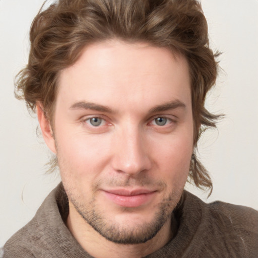 Joyful white young-adult male with short  brown hair and blue eyes