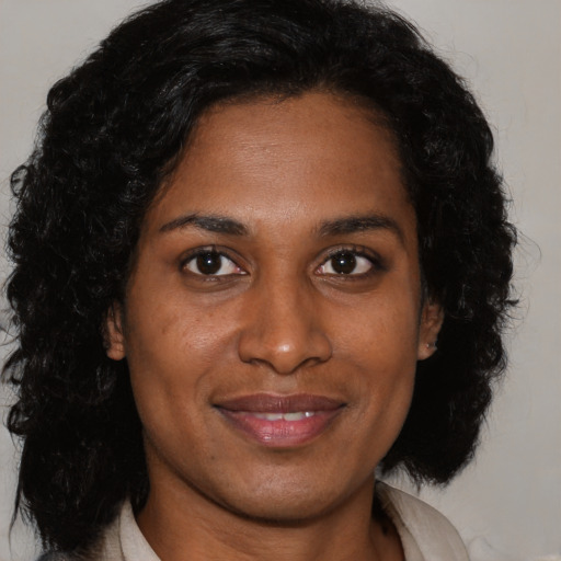 Joyful black young-adult female with medium  brown hair and brown eyes