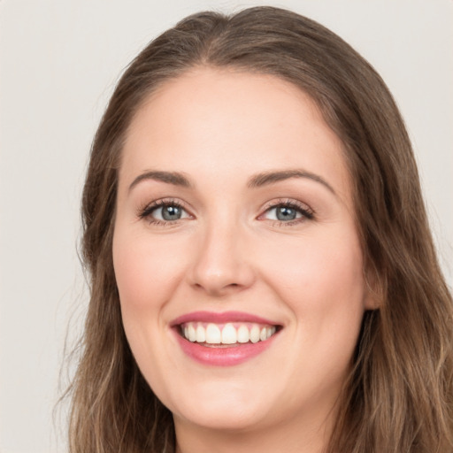 Joyful white young-adult female with long  brown hair and green eyes