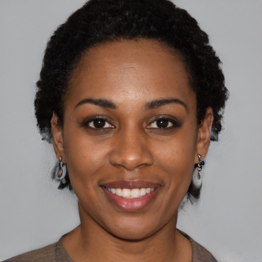 Joyful black young-adult female with short  black hair and brown eyes