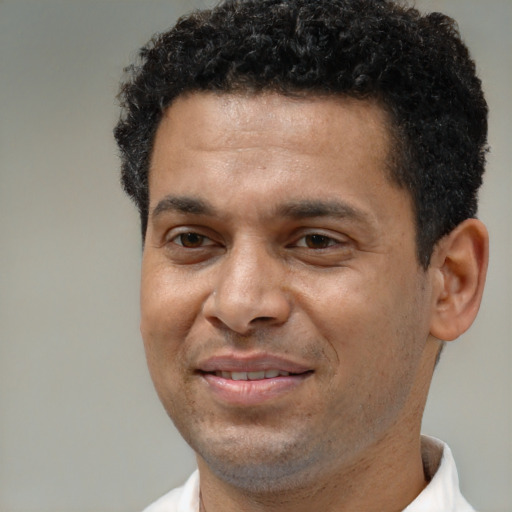 Joyful latino adult male with short  brown hair and brown eyes
