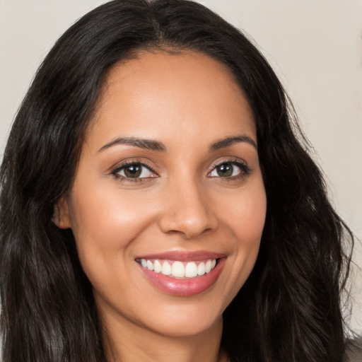 Joyful latino young-adult female with long  brown hair and brown eyes