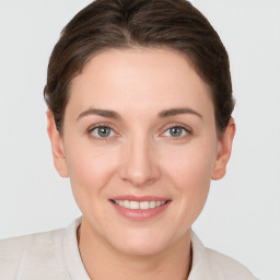 Joyful white young-adult female with short  brown hair and grey eyes